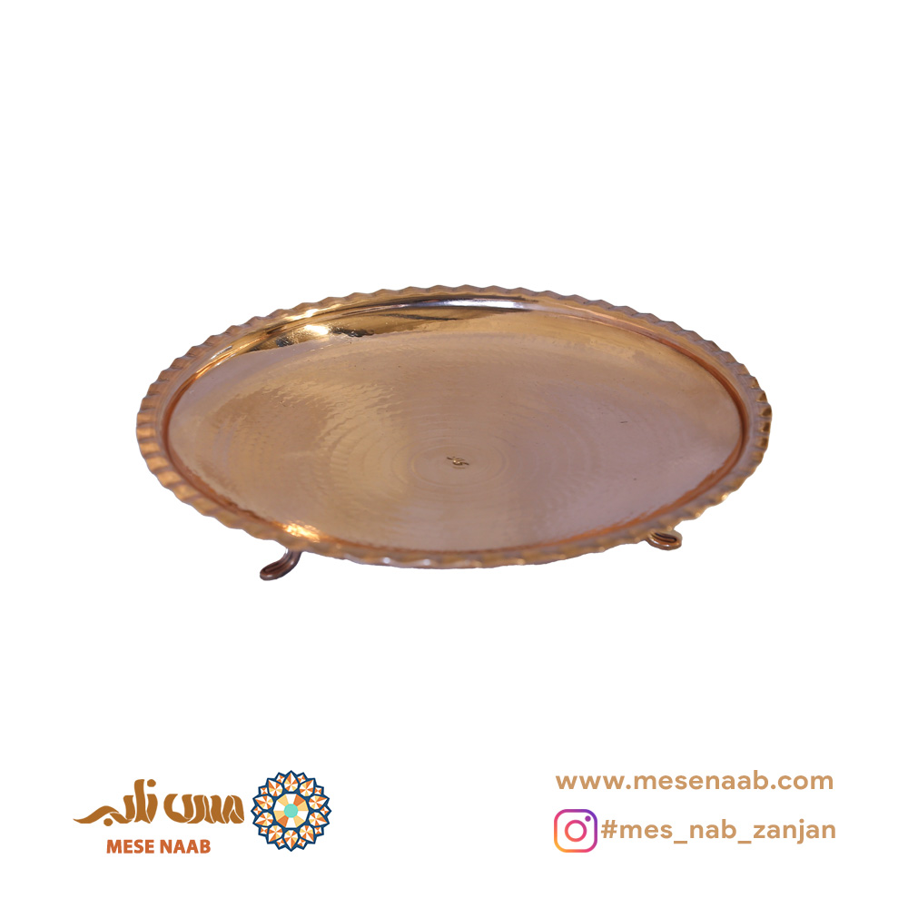 شیرینی خوری شاه عباسی لب کنگره دار نانو، یکی از شاهکارهای صنایع دستی استان زنجان است که با هنر و دقت استادکاران مسگر طراحی و ساخته شده است. این محصول خاص و زیبا، با الهام از طرحهای سنتی شاهعباسی و استفاده از متریال مرغوب مس، به یکی از بهترین انتخابها برای سرو شیرینی و دسر در مراسمها و دورهمیها تبدیل شده است. بدنه این ظرف با چکشکاری یکدست و حرفهای شکل گرفته است؛ چکشکاریای که علاوه بر ایجاد جلوهای براق و چشمنواز، به محصول اصالت و هویتی خاص میبخشد. سطح چکشی این شیرینی خوری، نور را با ظرافت بازتاب میدهد و زیبایی آن را در هر محیطی چند برابر میکند. این ویژگی باعث میشود که شیرینی خوری شاه عباسی لب کنگره دار نانو، بهتنهایی هم یک اثر هنری و دکوری محسوب شود. لبههای این محصول با دقتی مثالزدنی بهصورت کنگرهای طراحی شدهاند. این کنگرههای منظم و یکدست، علاوه بر زیبایی بصری، حس یکپارچگی و اصالت بیشتری به ظرف میدهند. طراحی تخت این شیرینیخوری نیز بهگونهای است که فضای کافی برای چیدمان شیرینیها، دسرها یا حتی تنقلات مختلف فراهم میکند. چیدمان محصولات روی این ظرف بسیار آسان است و جلوهای خاص و مرتب به میز پذیرایی شما میبخشد. این شیرینی خوری شاه عباسی لب کنگره دار نانو دارای سه پایهی مستحکم و زیبا از جنس مس خالص است. این پایهها ظرف را در ارتفاعی مناسب قرار میدهند تا هم دسترسی به شیرینیها آسانتر شود و هم ظرف بهتر دیده شود. وجود سه پایه باعث میشود که ظرف روی هر سطحی کاملاً ثابت و متعادل بایستد و از لق زدن یا تکان خوردن آن جلوگیری شود. یکی از ویژگیهای برجسته این محصول، پوشش نانو است که روی سطح آن اعمال شده است. این روکش نانو باعث میشود ظرف دیرتر کدر شود، در برابر لکهها مقاومت بیشتری داشته باشد و در طول زمان درخشش و زیبایی خود را حفظ کند. بنابراین، این شیرینیخوری علاوه بر زیبایی و کاربرد، نگهداری آسانی نیز دارد و نیاز به جلا دادن مکرر ندارد. این ظرف مسی، گزینهای عالی برای استفاده در مهمانیها، جشنها و دورهمیهای خانوادگی است. طراحی شکیل و سنتی آن، به میز شما حالوهوای اصیل و ایرانی میبخشد و میتواند مکملی زیبا برای دیگر ظروف پذیرایی مسی یا ظروف دکوری شما باشد. همچنین، این شیرینی خوری شاه عباسی لب کنگره دار نانو بهخوبی با دکوراسیونهای مدرن و کلاسیک هماهنگ میشود و به محیط گرما و جذابیت میبخشد. اگر به دنبال هدیهای ارزشمند و متفاوت هستید، این شیرینی خوری میتواند یک انتخاب فوقالعاده باشد. بهخصوص برای مناسبتهایی مانند شب یلدا، نوروز، جشنهای خانوادگی یا حتی جهیزیه، این ظرف مسی دستساز میتواند هدیهای ماندگار و بهیادماندنی باشد. در یک نگاه، شیرینی خوری شاه عباسی لب کنگره دار نانو ترکیبی است از: هنر اصیل مسگری استان زنجان طراحی شاهعباسی با لبههای کنگرهای یکدست بدنه چکشی برای زیبایی و استحکام بیشتر پوشش نانو برای دوام و نگهداری آسان سه پایهی مسی برای تعادل و جلوهی بهتر این محصول نهتنها یک ظرف کاربردی برای سرو شیرینی و دسر است، بلکه یک اثر هنری دستساز است که میتواند زینتبخش خانه و میز پذیرایی شما باشد.